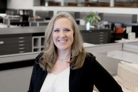 A woman in an office smiling at the camera.