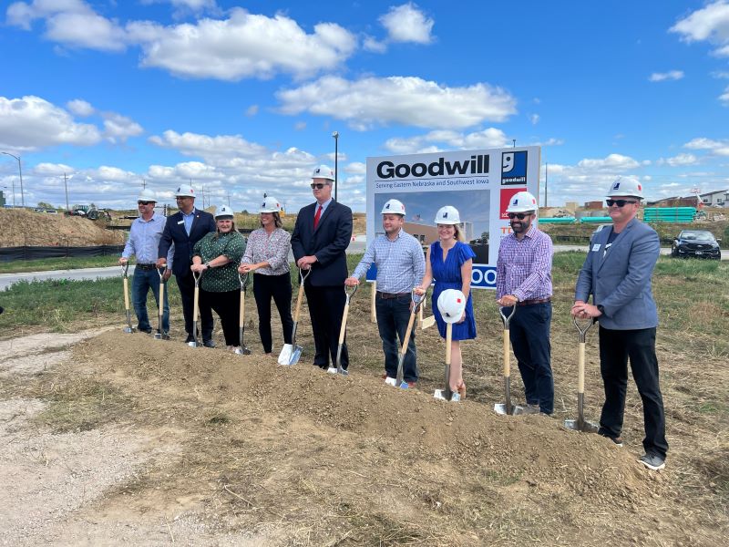 People in hard hats smiling at the camera at a groundbreaking ceremony